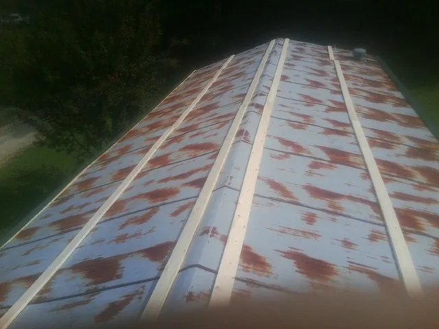 Rusted metal roof panels with new wood purlins before replacement — Storm Damage Roof Repair in Temple Hills by Roofing Brothers