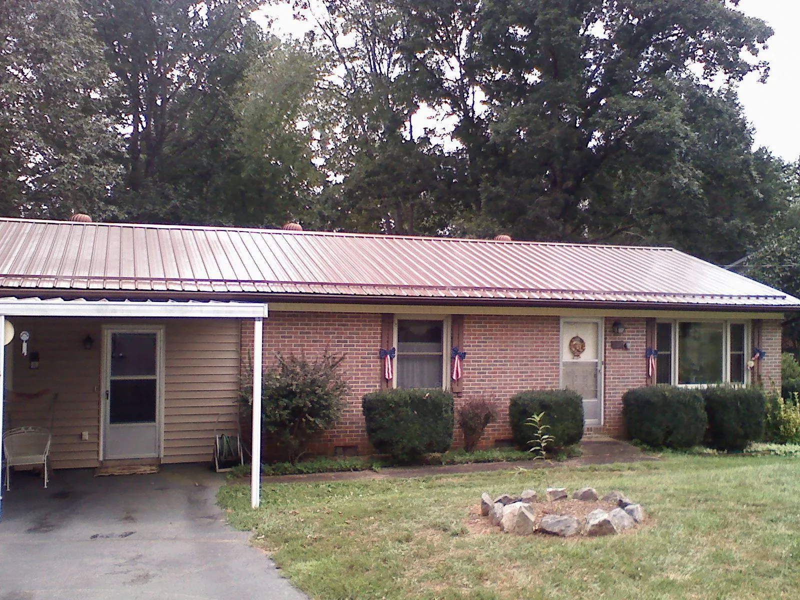 Bronze metal roof and carport on a brick ranch home — Roof Repair work by our crew in Temple Hills